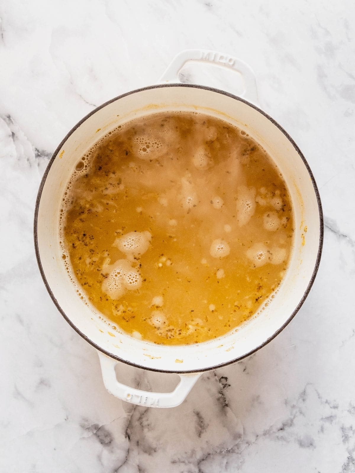 Soup pot with the broth and beans added to the sauteed aromatics.