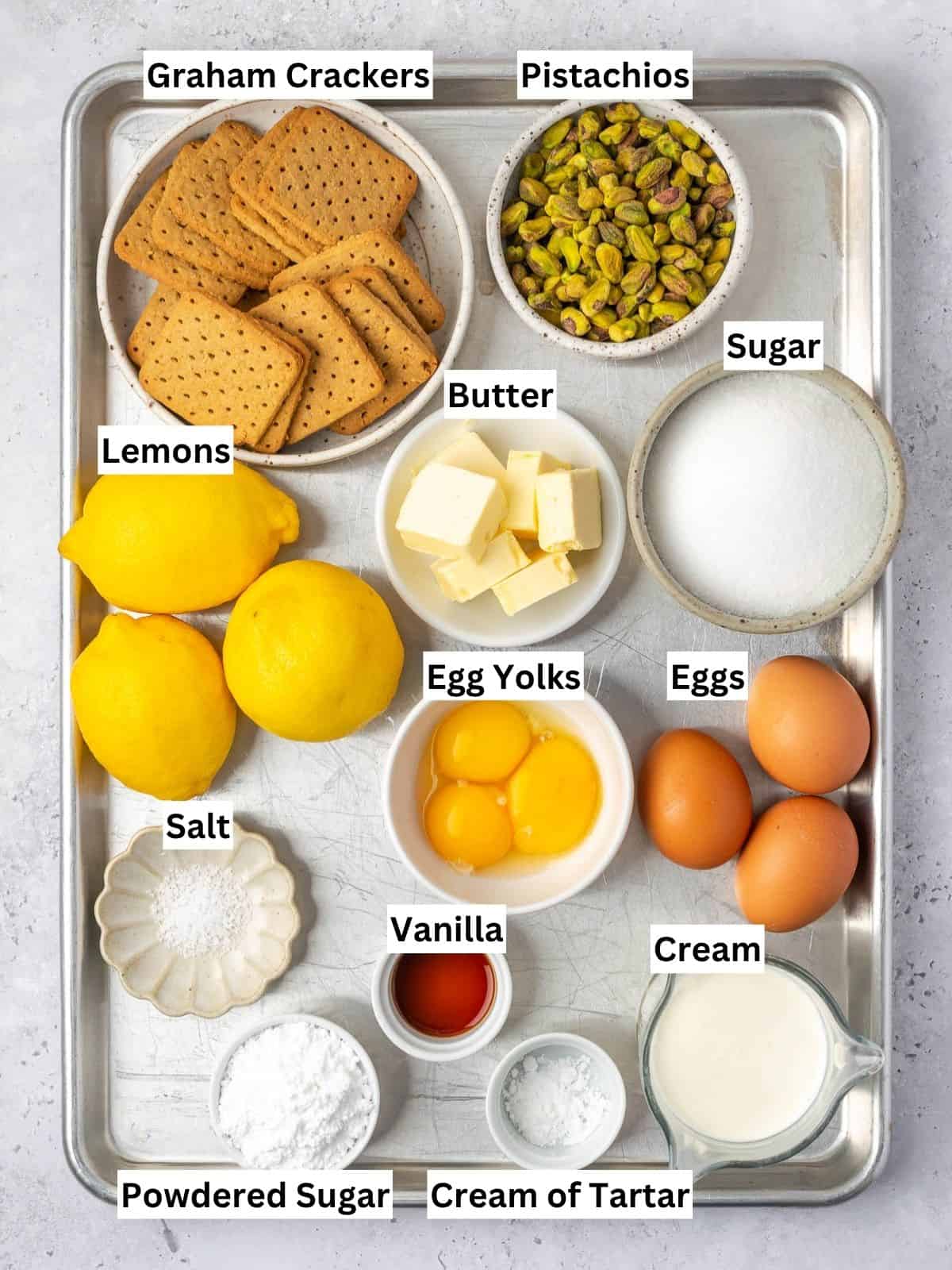Lemon curd tart with pistachios recipe ingredients with individual labels on a metal tray.