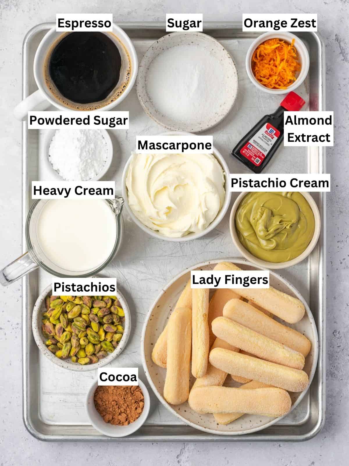 Orange pistachio tiramisu recipe ingredients with individual labels on a metal tray.
