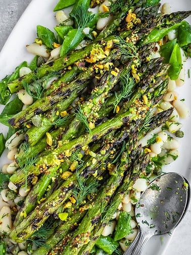Platter with white beans and grilled asparagus spears.