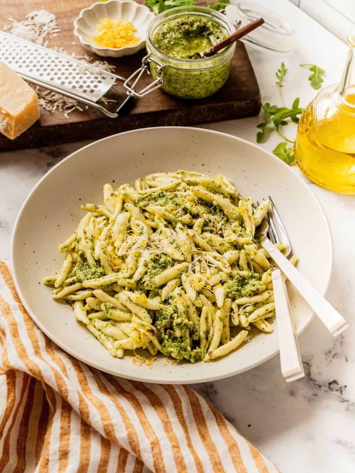 A bowl of pasta tossed with arugula pesto.