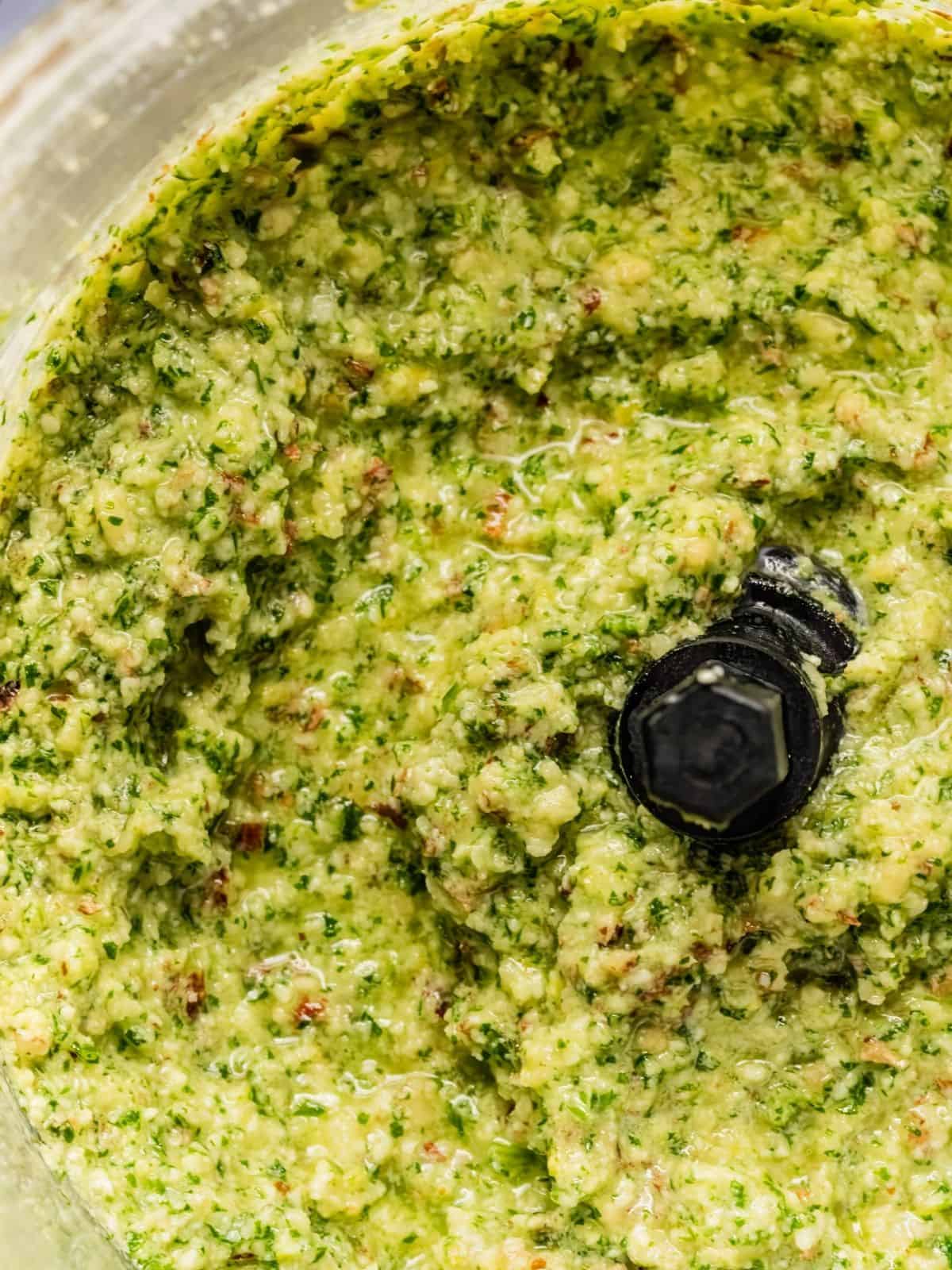 The processed arugula pesto in a food processor.