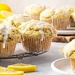 Lemon poppy seed muffins with lemon icing on a cooling rack.