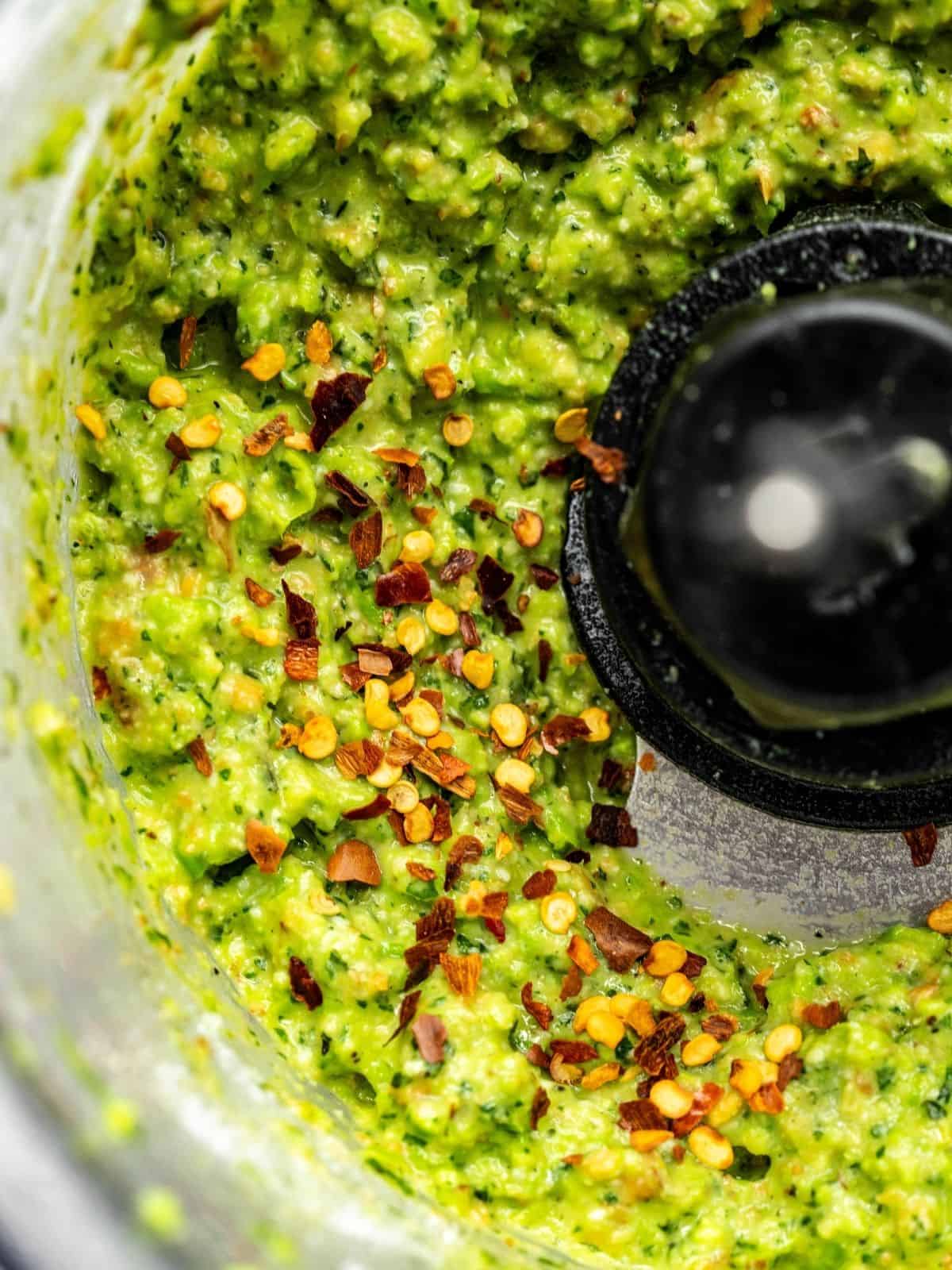 Pea pesto getting seasoned in a food processor.