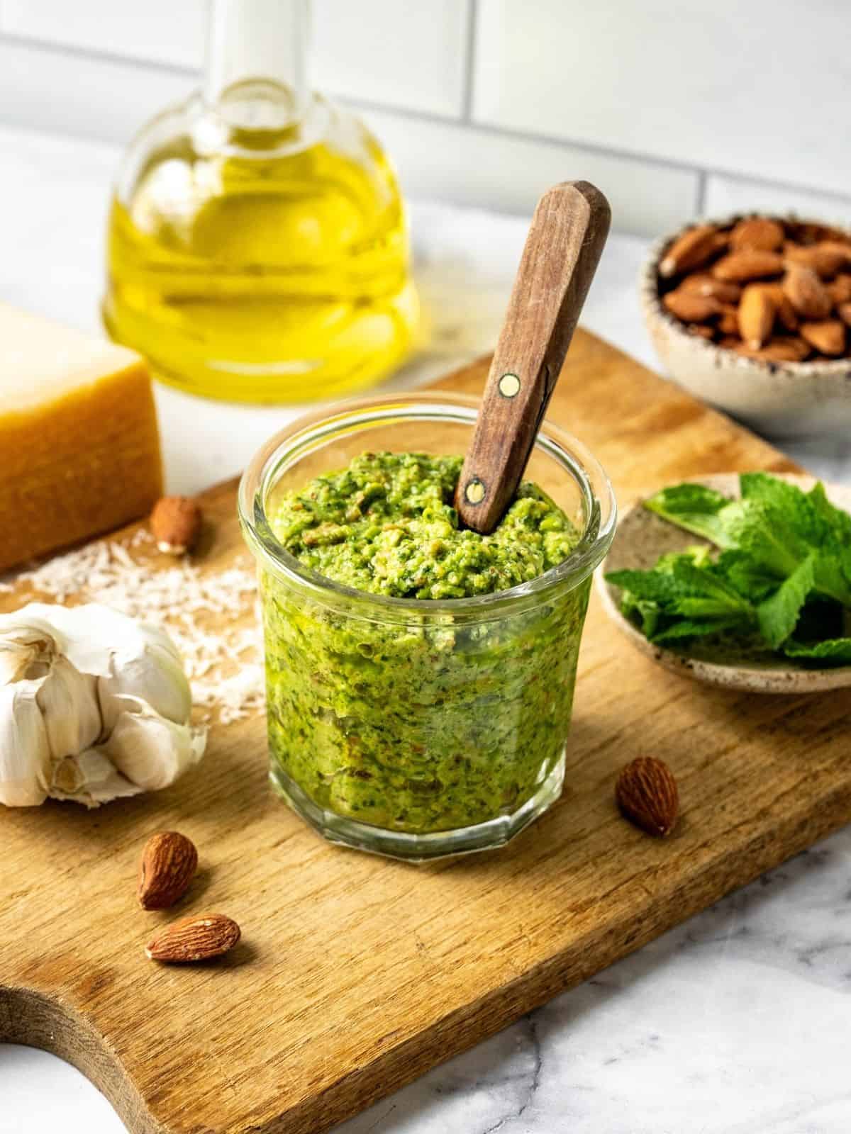 Pea and mint pesto in a mason jar on a wooden board.
