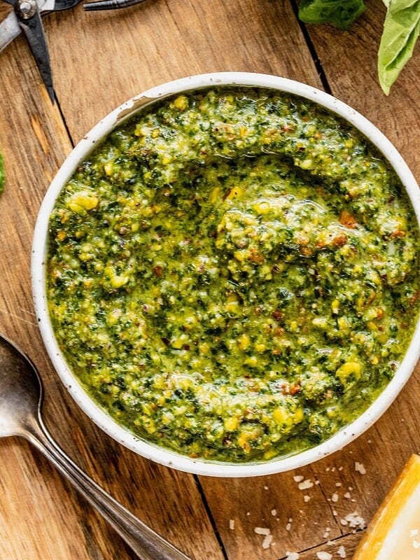 Bowl of pistachio pesto on a wooden tray.