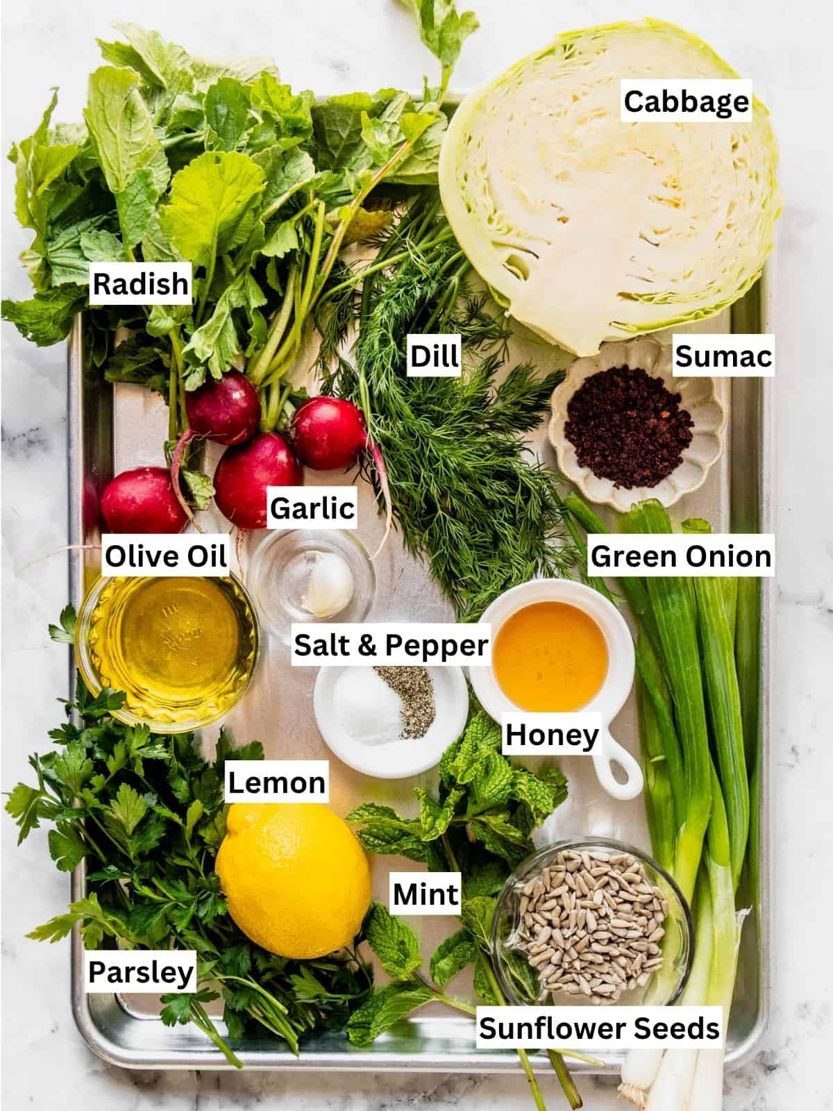 No mayo coleslaw with lemon sumac dressing recipe ingredients with individual labels on a metal tray.