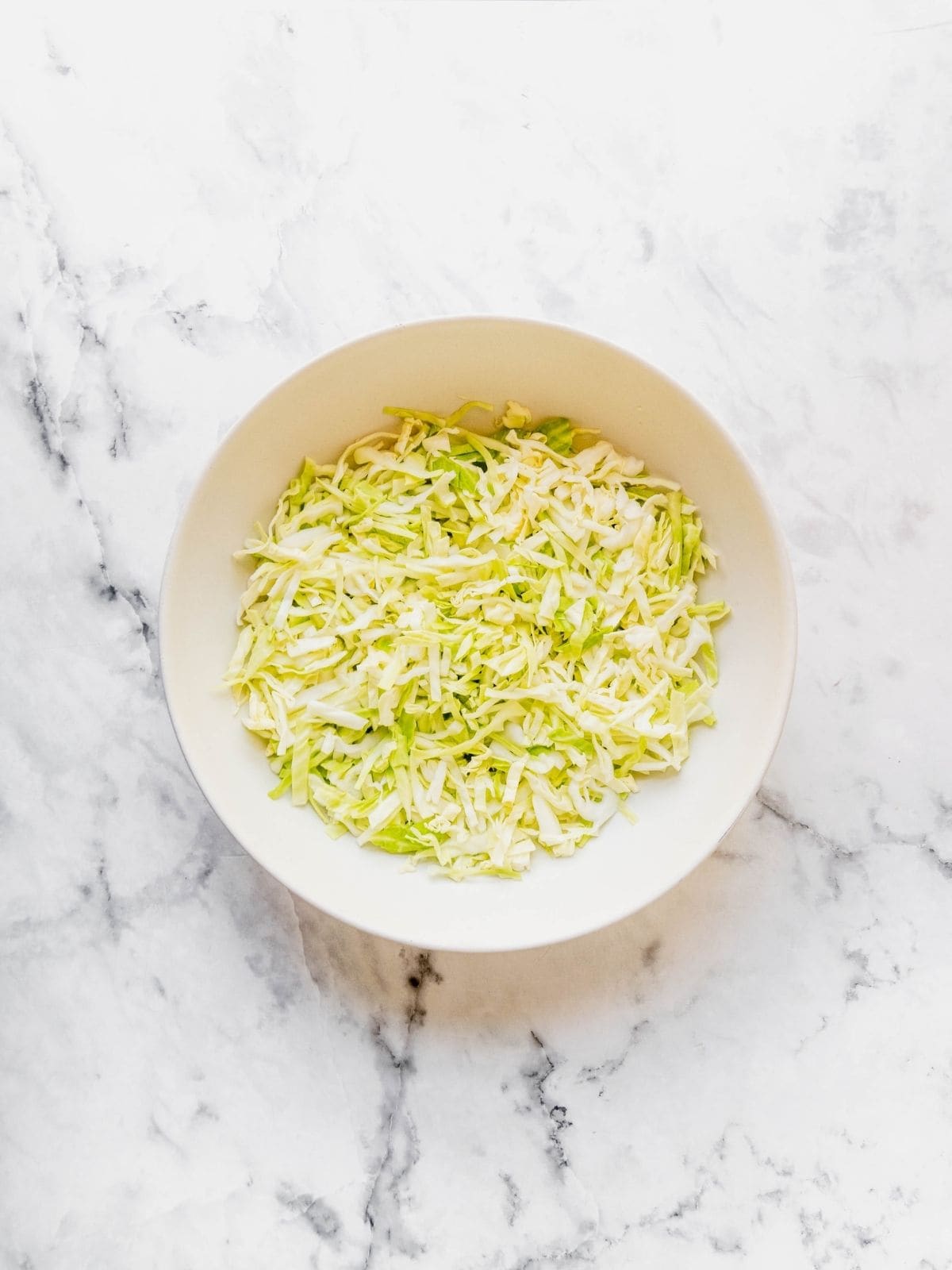 Shredded salted cabbage in a bowl.