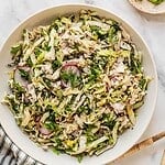No mayo coleslaw with radish, fresh herbs in a lemon sumac dressing in a bowl.