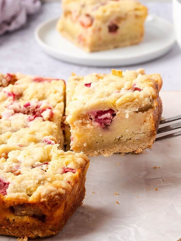 Sliced rhubarb custard bars on a wooden board.