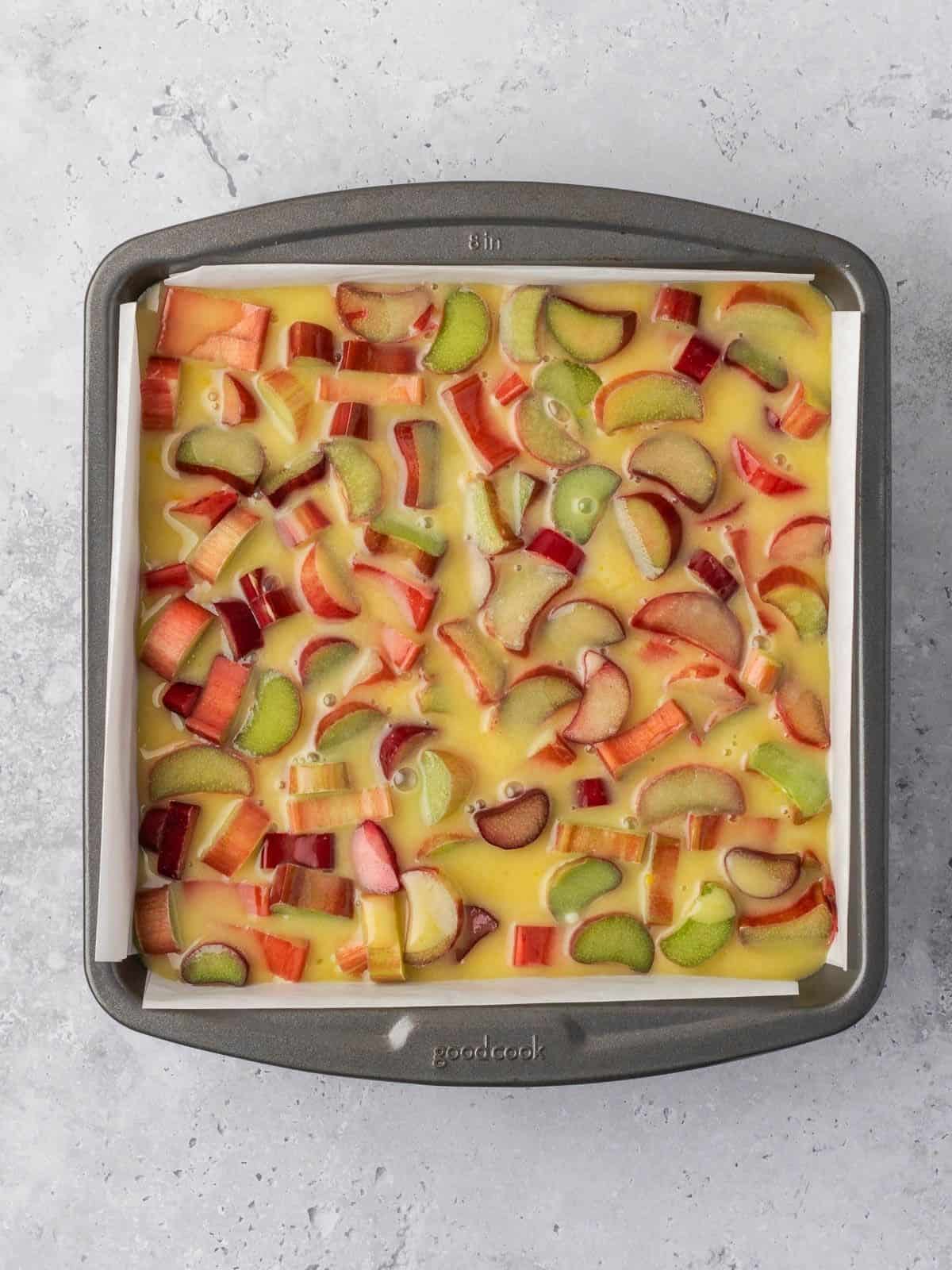 Parbaked crust covered with sliced rhubarb and custard mixture.