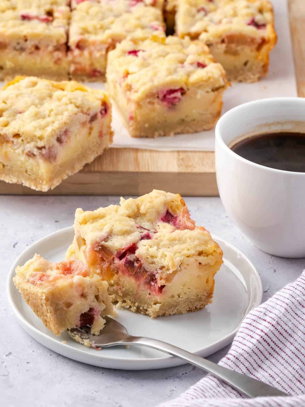 A rhubarb custard square on a plate with a side of coffee.