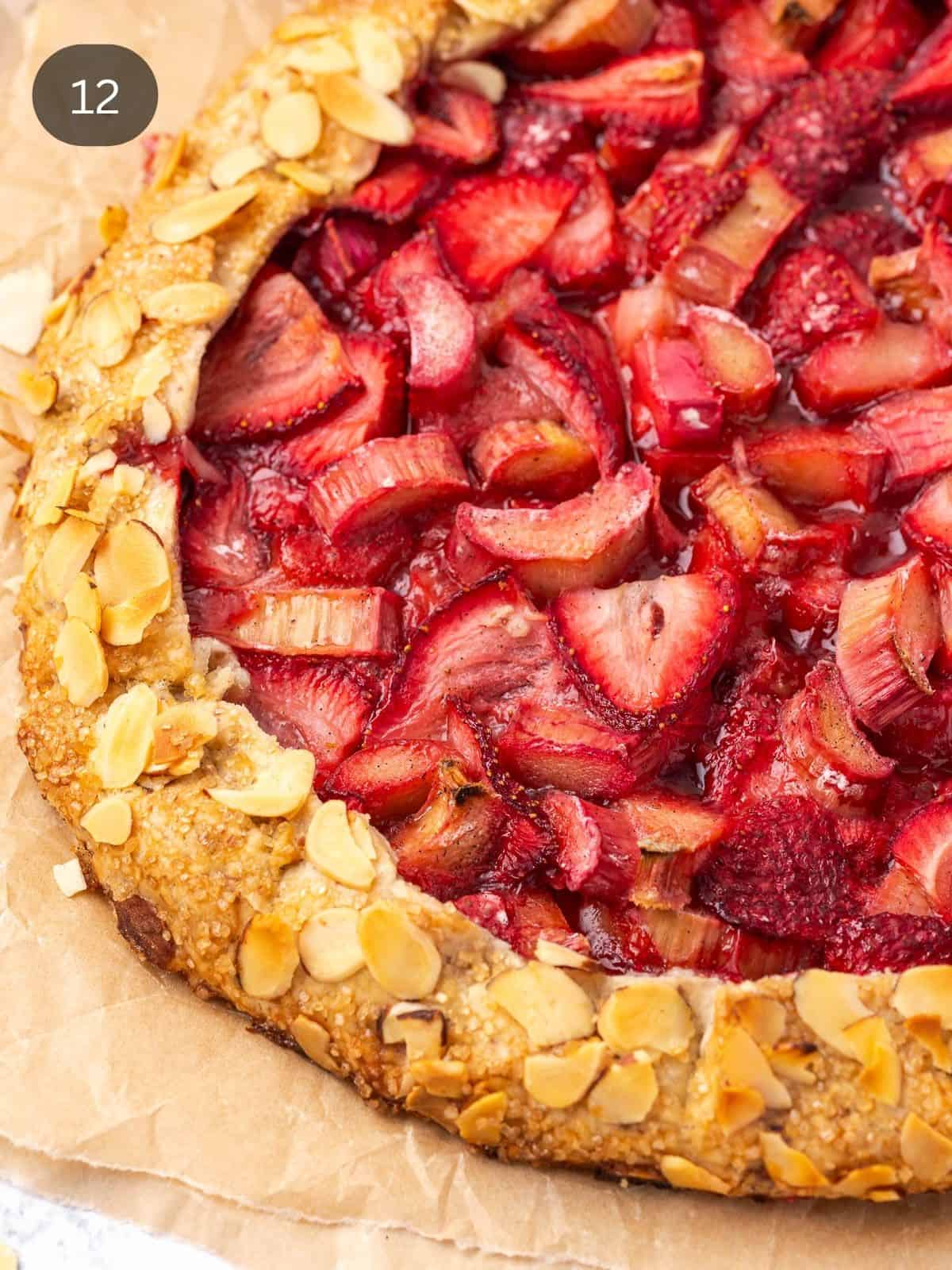 Strawberry rhubarb galette with almond crust on parchment paper.