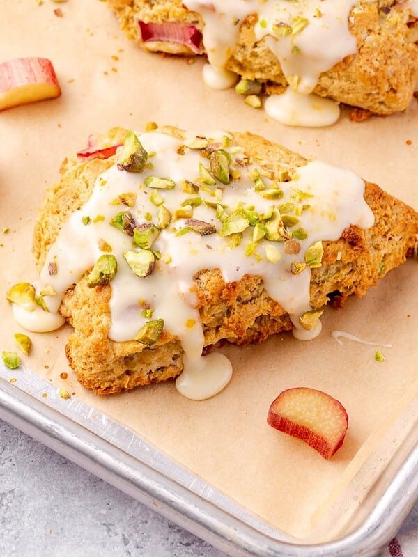 Rhubarb Scones with Orange and Pistachios on parchment paper lined baking sheet.
