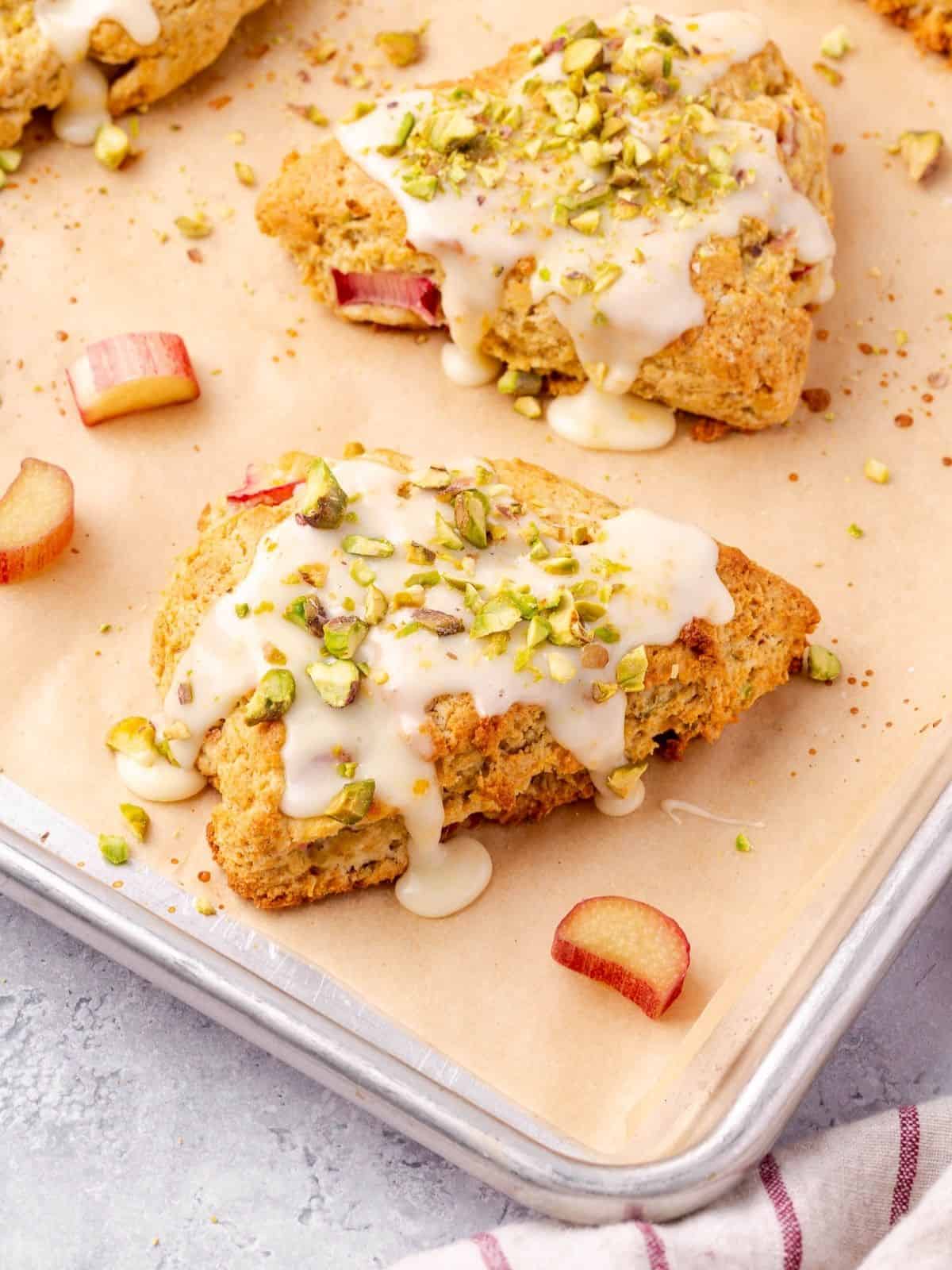 Rhubarb Scones with Orange and Pistachios on parchment paper lined baking sheet.