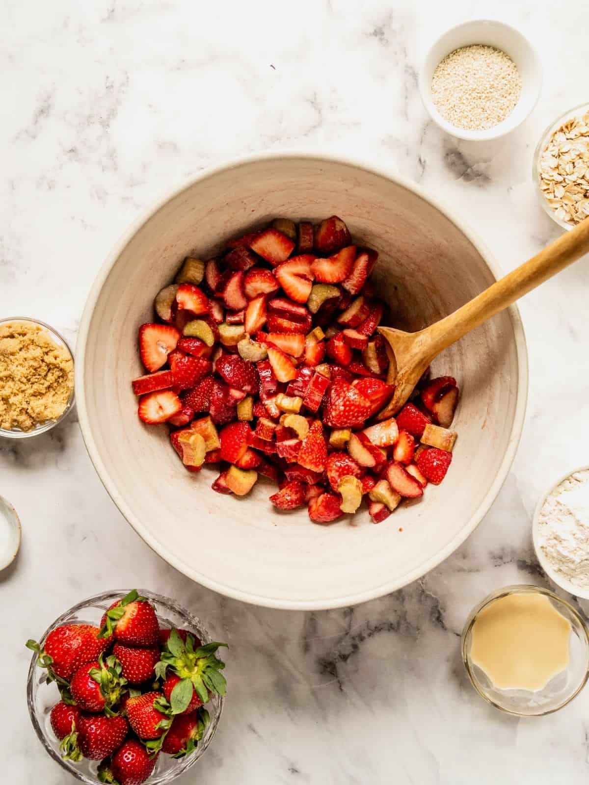 Strawberries, rhubarb, cornstarch, sugar and flavorings in a bowl.