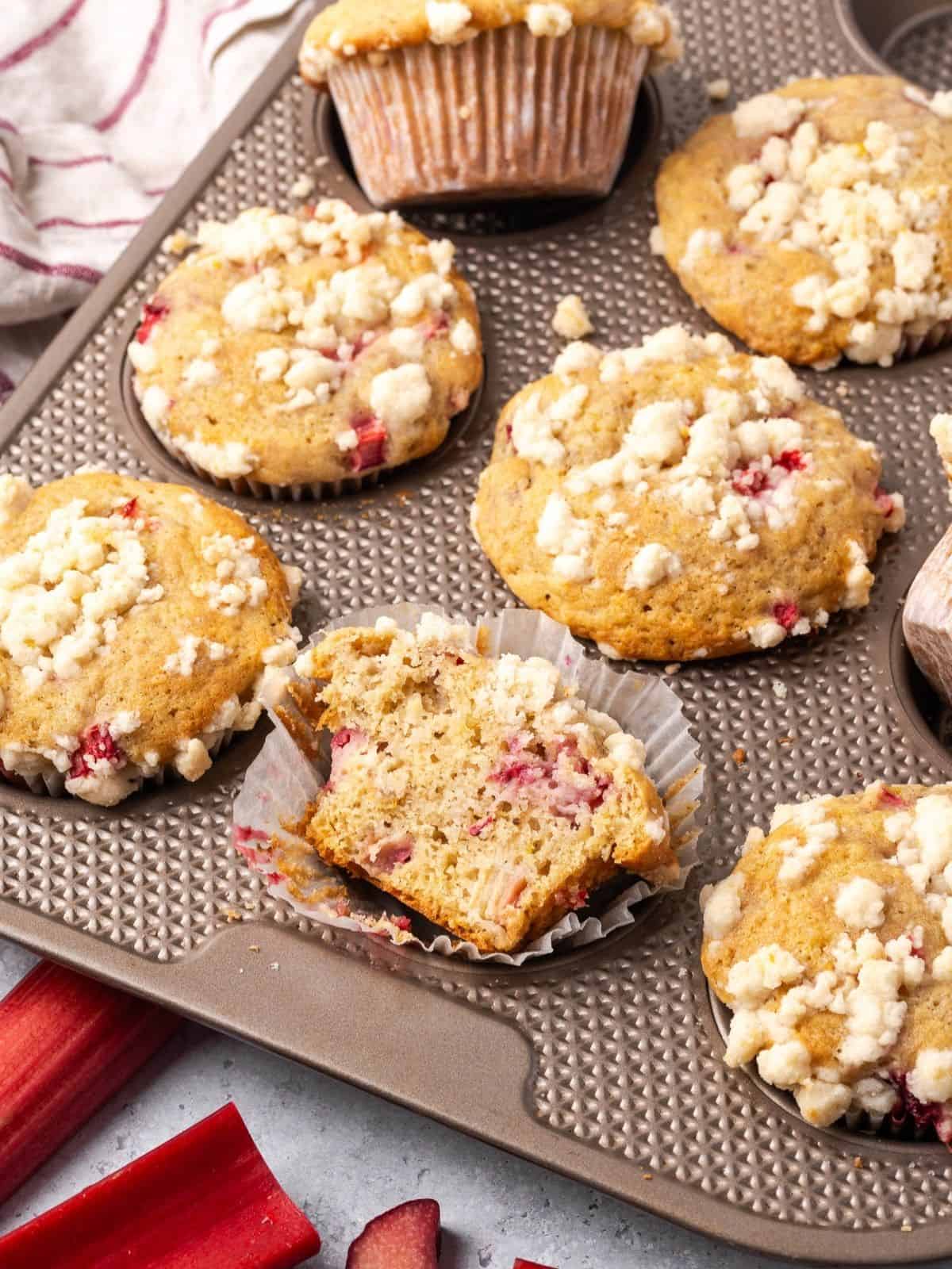 Baked strawberry rhubarb muffins with lemon streusel topping in a muffin tin.