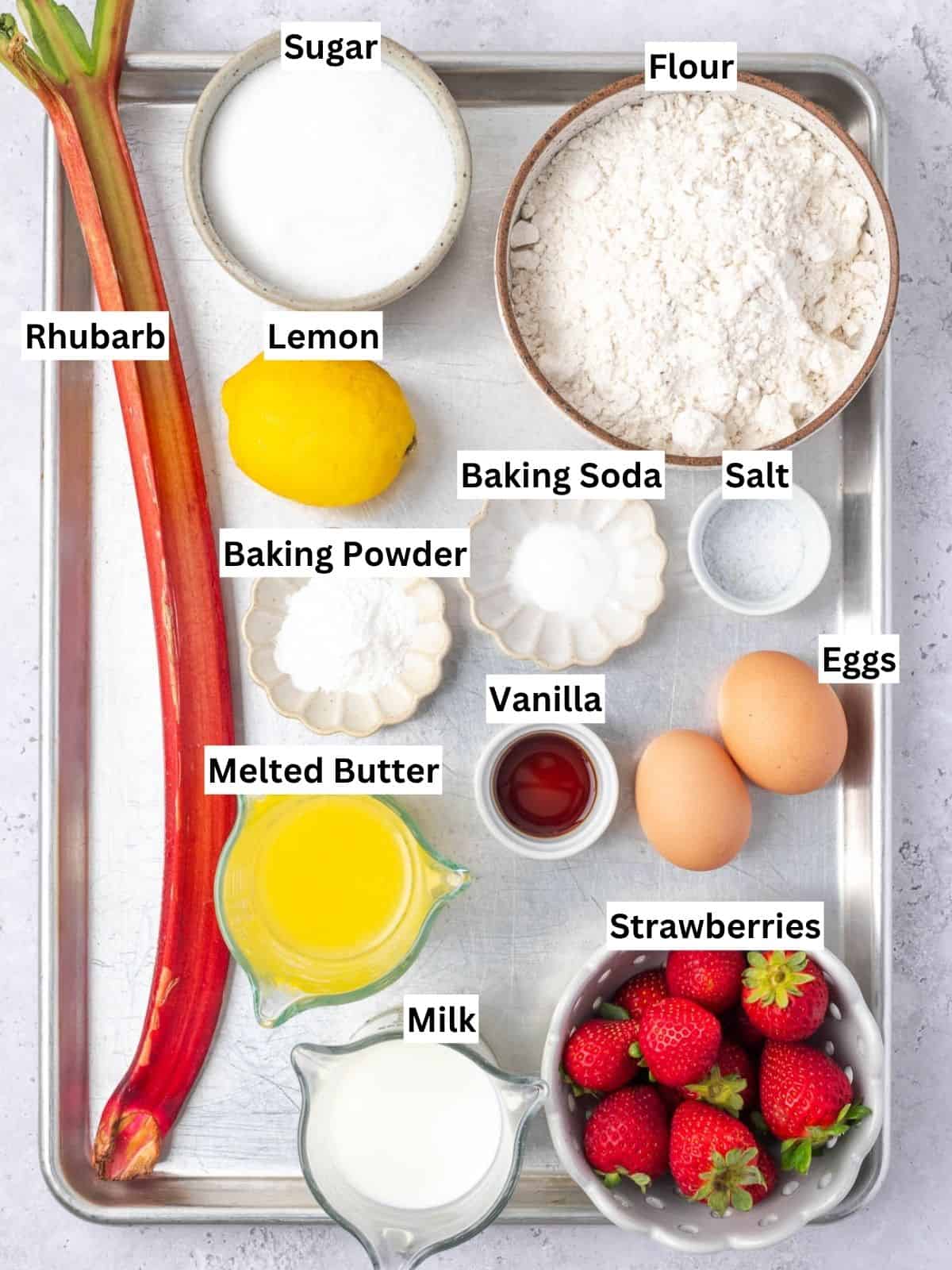 Baked strawberry rhubarb muffins with lemon streusel topping recipe ingredients with individual labels on a metal tray.