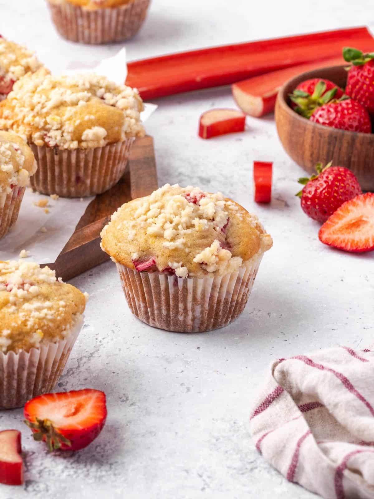 Strawberry rhubarb muffins with lemon streusel topping on a wooden board.