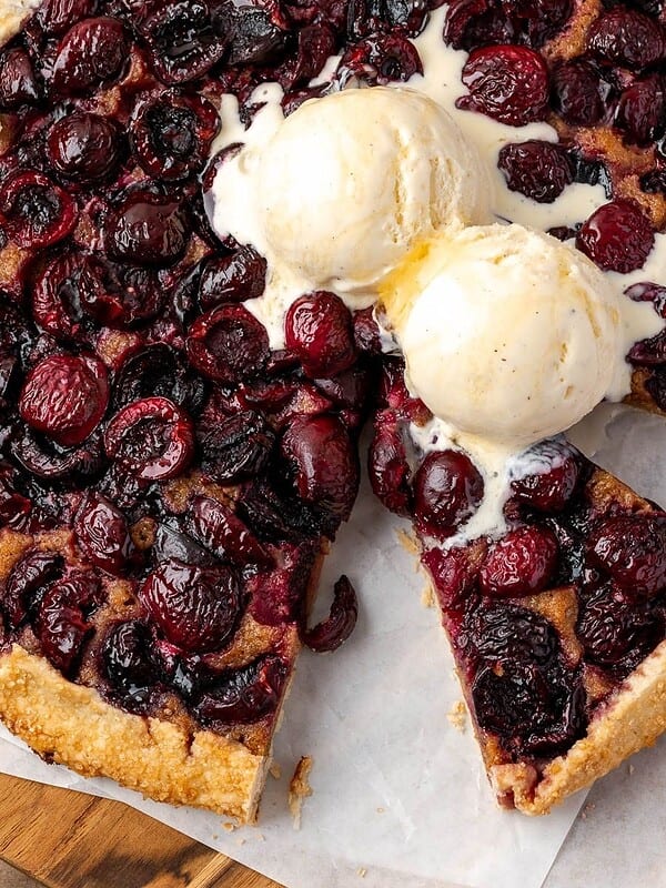 Cherry galette with walnut frangipane topped with two scoops of vanilla ice cream.