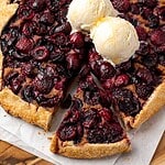 Cherry galette with walnut frangipane topped with two scoops of vanilla ice cream.