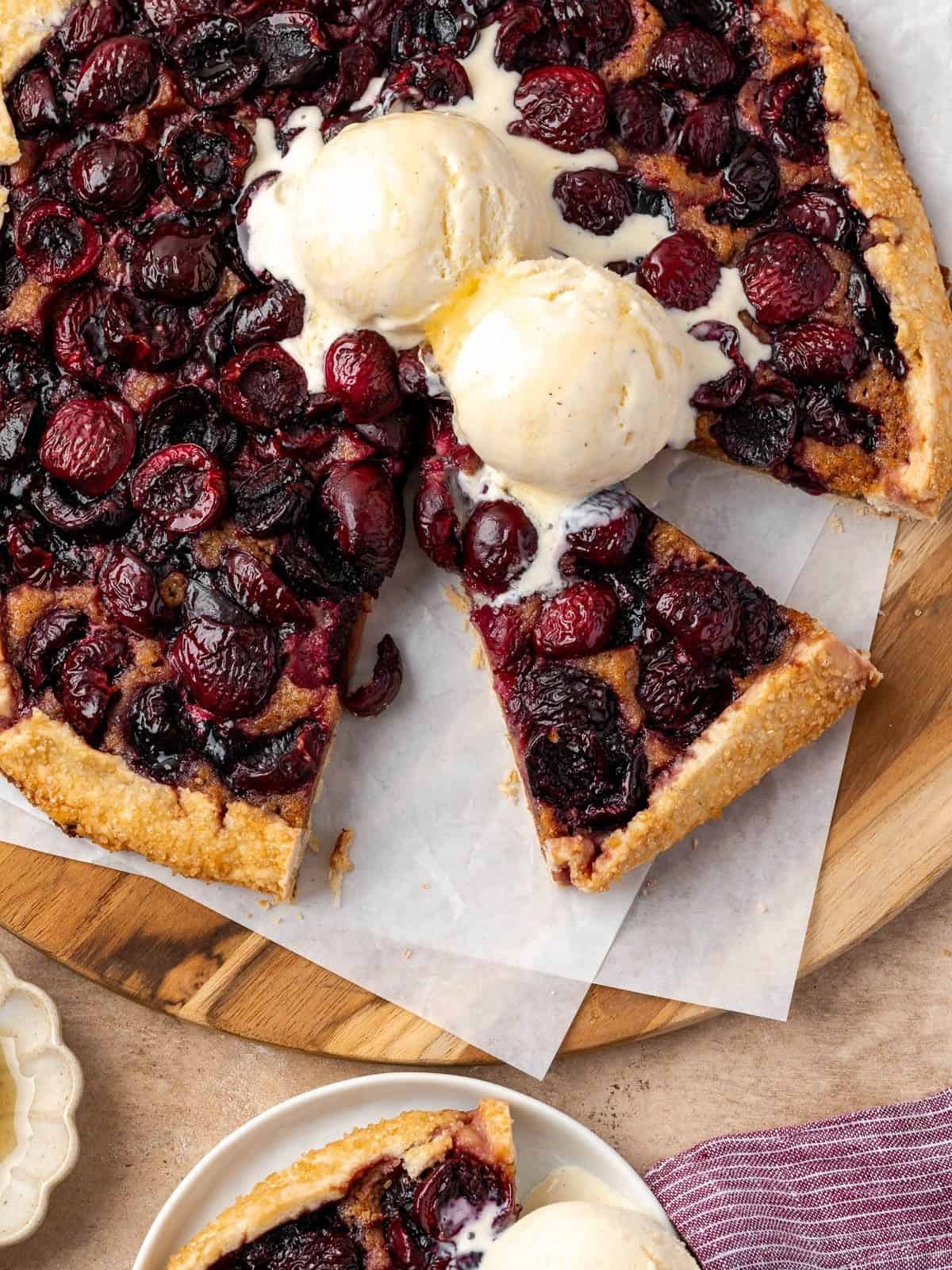 Cherry galette with walnuts and honey topped with two scoops of vanilla ice cream.