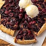 Cherry galette with walnut frangipane topped with two scoops of vanilla ice cream.