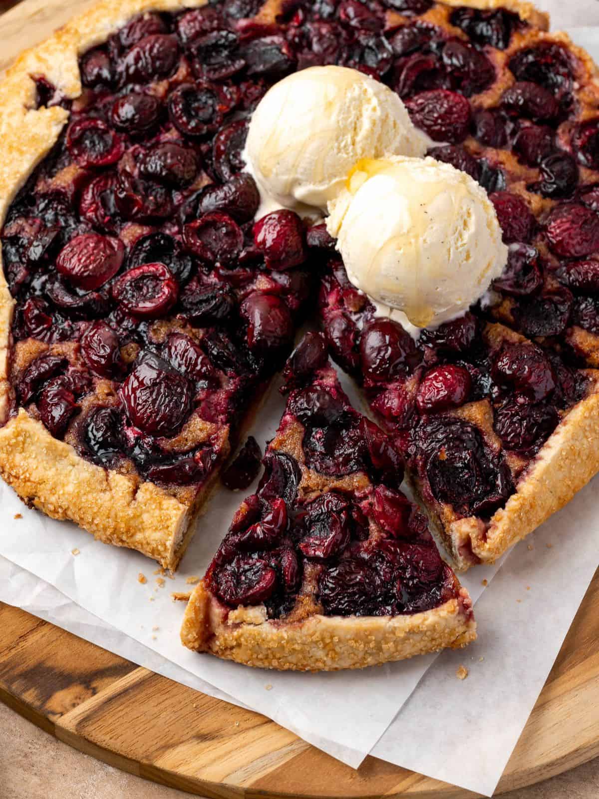 Cherry galette with walnut frangipane topped with two scoops of vanilla ice cream.