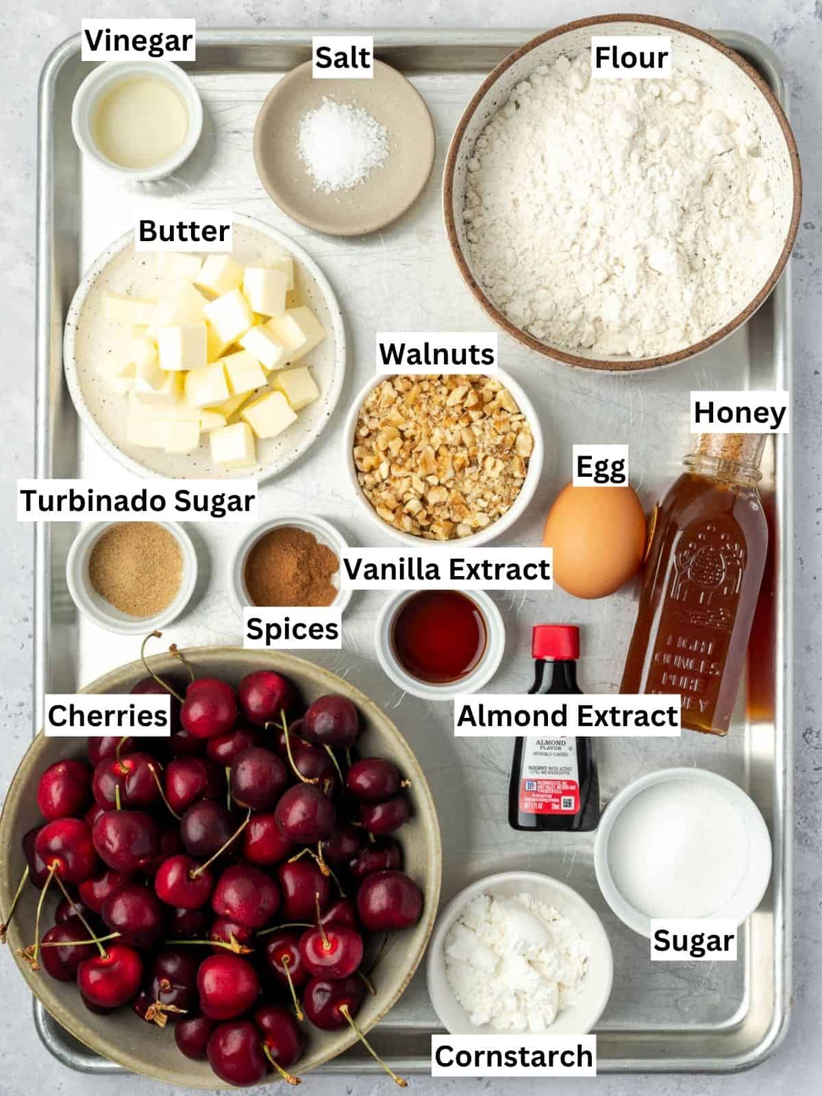 Cherry Galette with Walnut Frangipane and Honey recipe ingredients with individual labels on a metal tray.