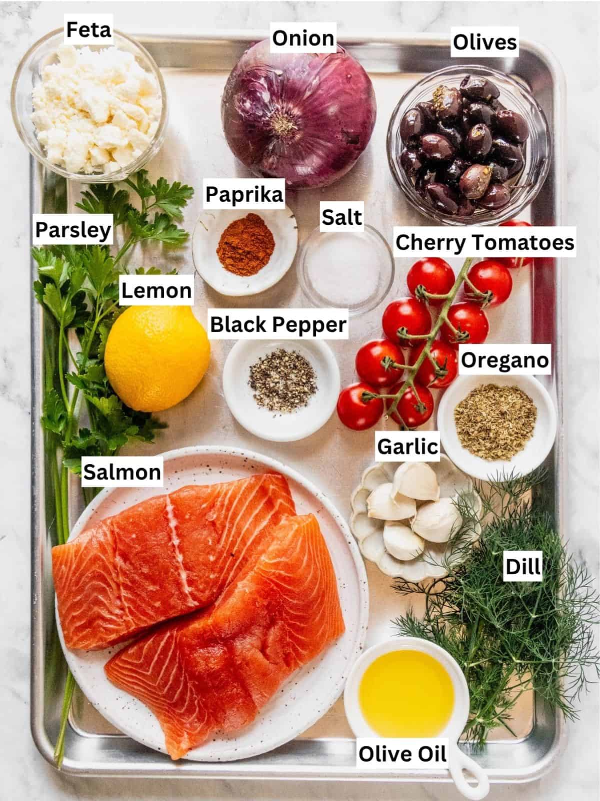 Greek Salmon with tomatoes, olives and feta recipe ingredients with individual labels on a metal tray.