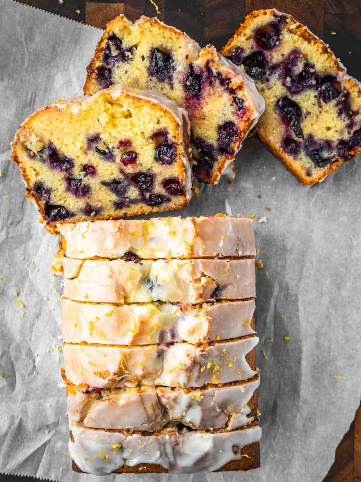 Freshly sliced blueberry lemon loaf cake on parchment paper.