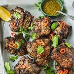 North African grilled lamb loin chops garnished with coriander and chili with a side of chermoula sauce.