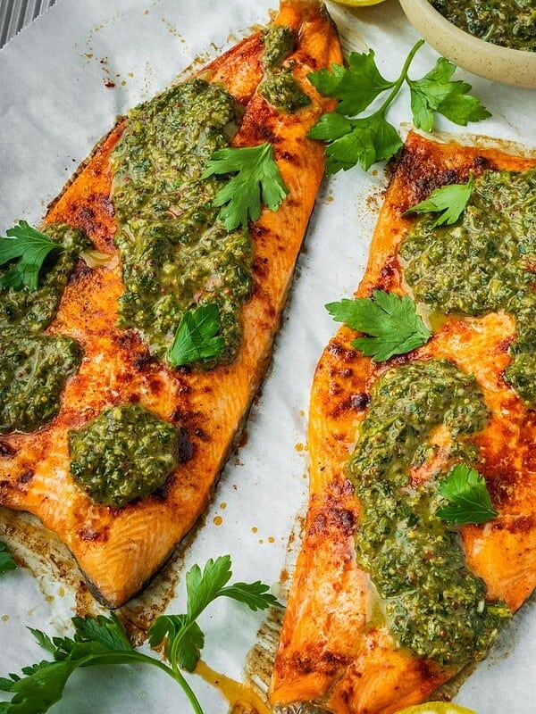 Baked Trout with Pomegranate Molasses Herb Sauce on a parchment paper lined tray.