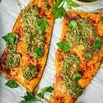 Baked Trout with Pomegranate Molasses Herb Sauce on a parchment paper lined tray.