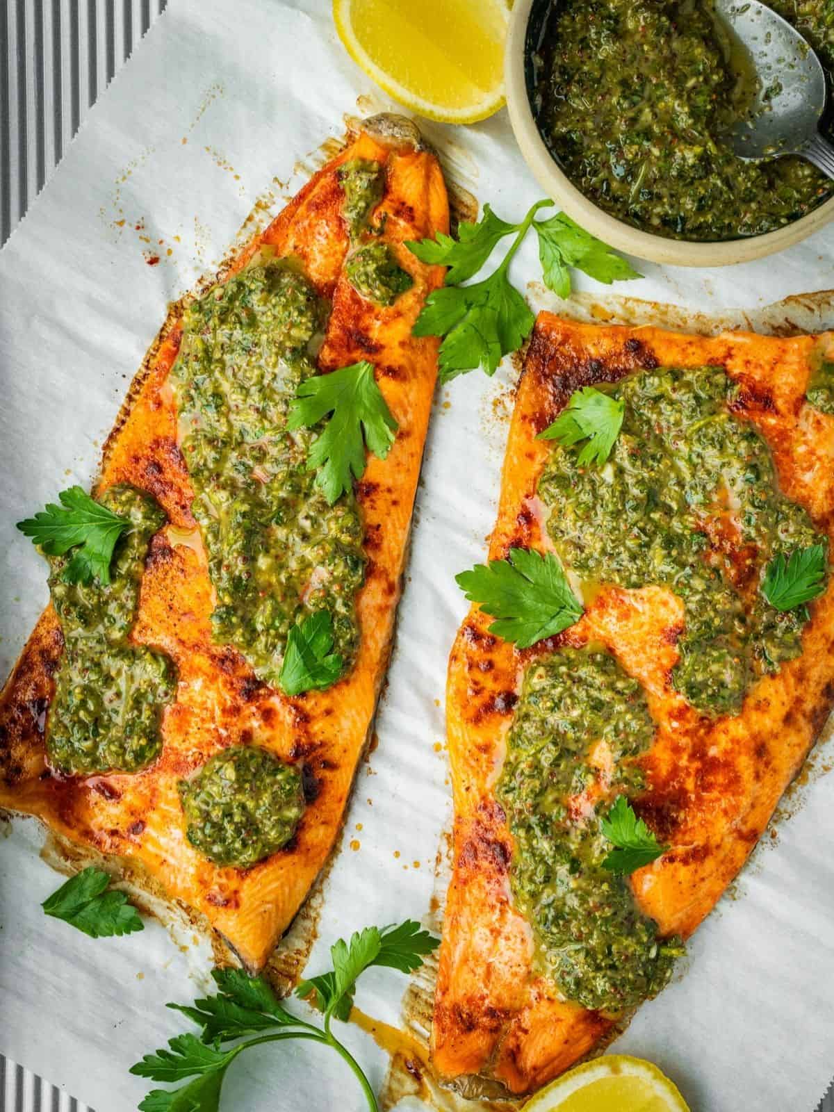 Baked Trout with Pomegranate Molasses Herb Sauce on a parchment paper lined tray.