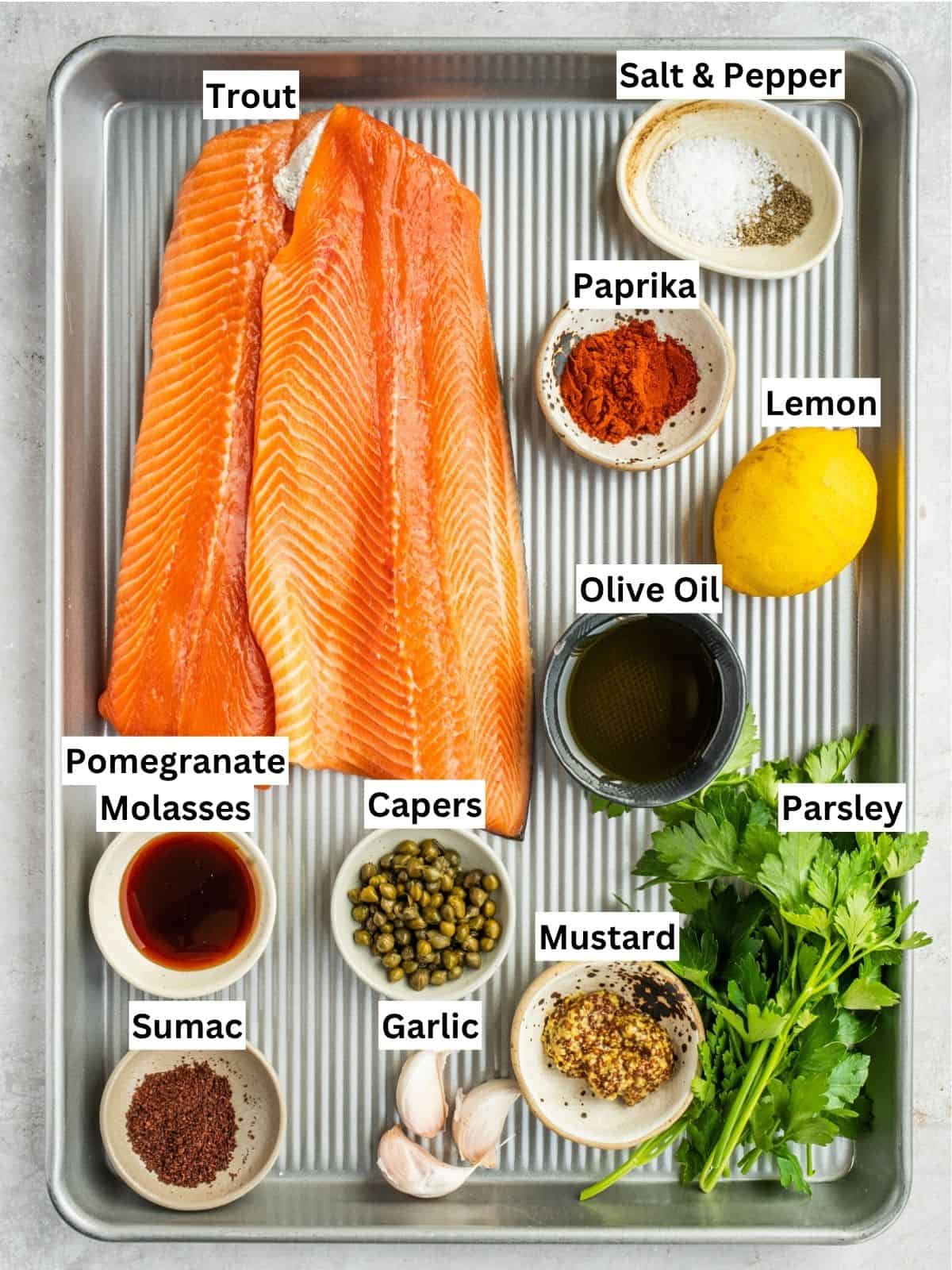 Baked Trout with Pomegranate Molasses Herb Sauce recipe ingredients with individual labels on a metal tray.