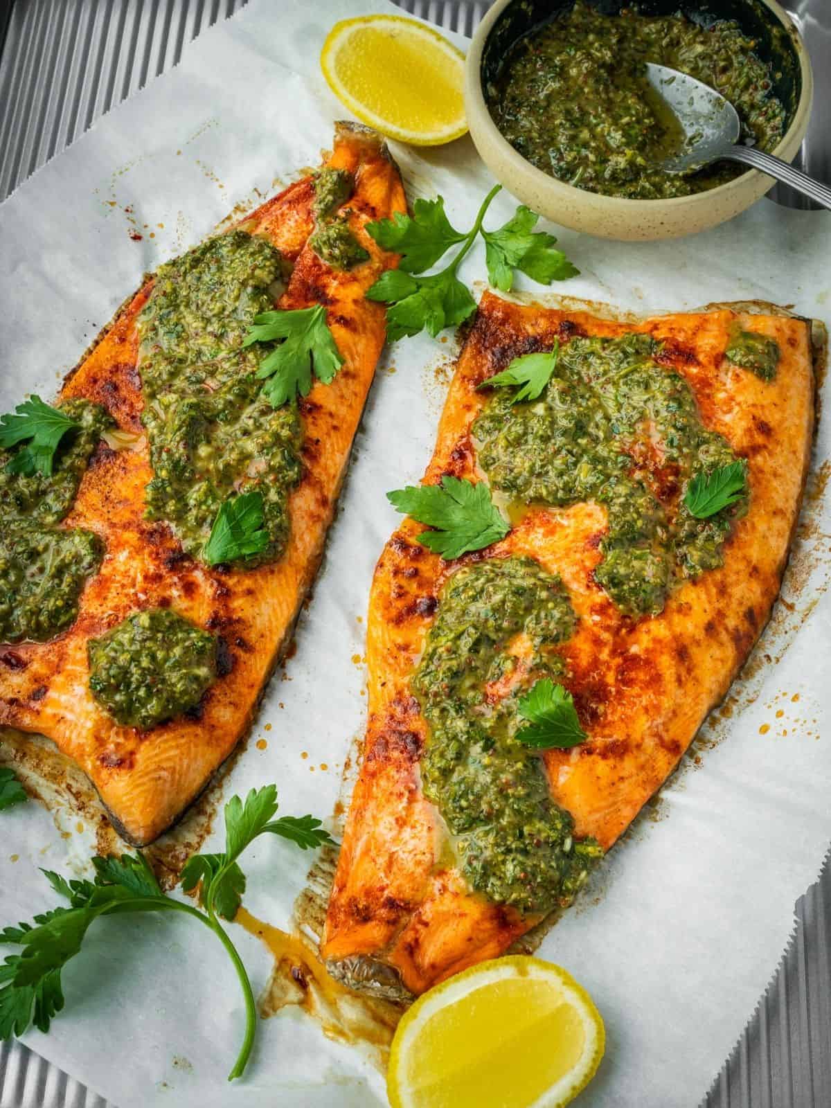 Baked Trout with Pomegranate Molasses Herb Sauce on a parchment paper lined tray.