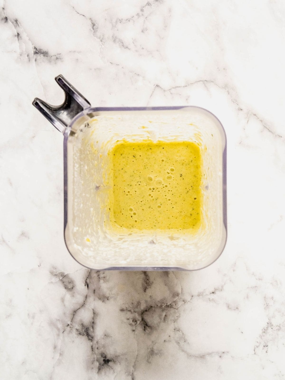 Blender jar with creamy corn and zucchini sauce.