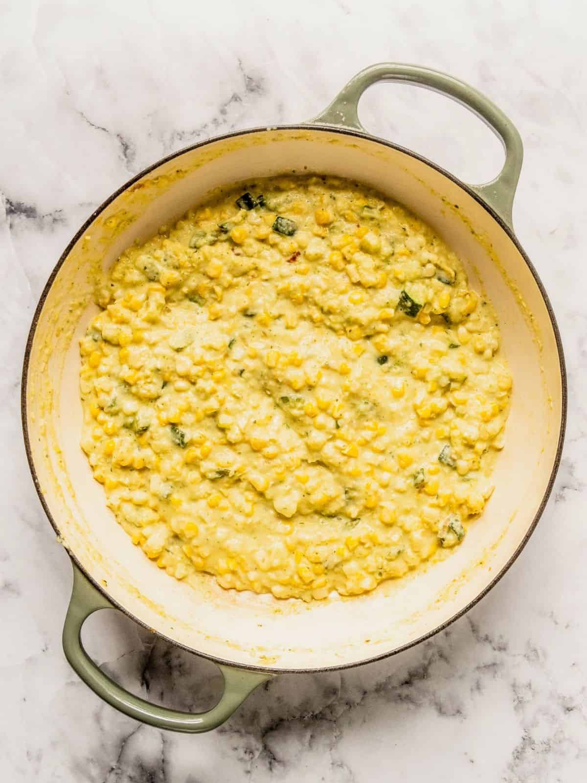 Sauce pan with corn, zucchini and creamy sauce.