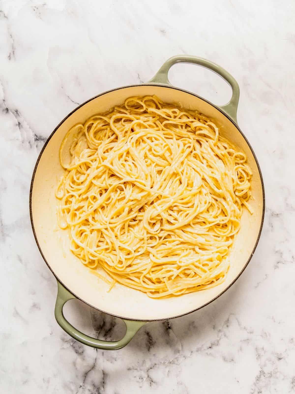 Saucepan with pasta tossed in the creamy lemon sauce.