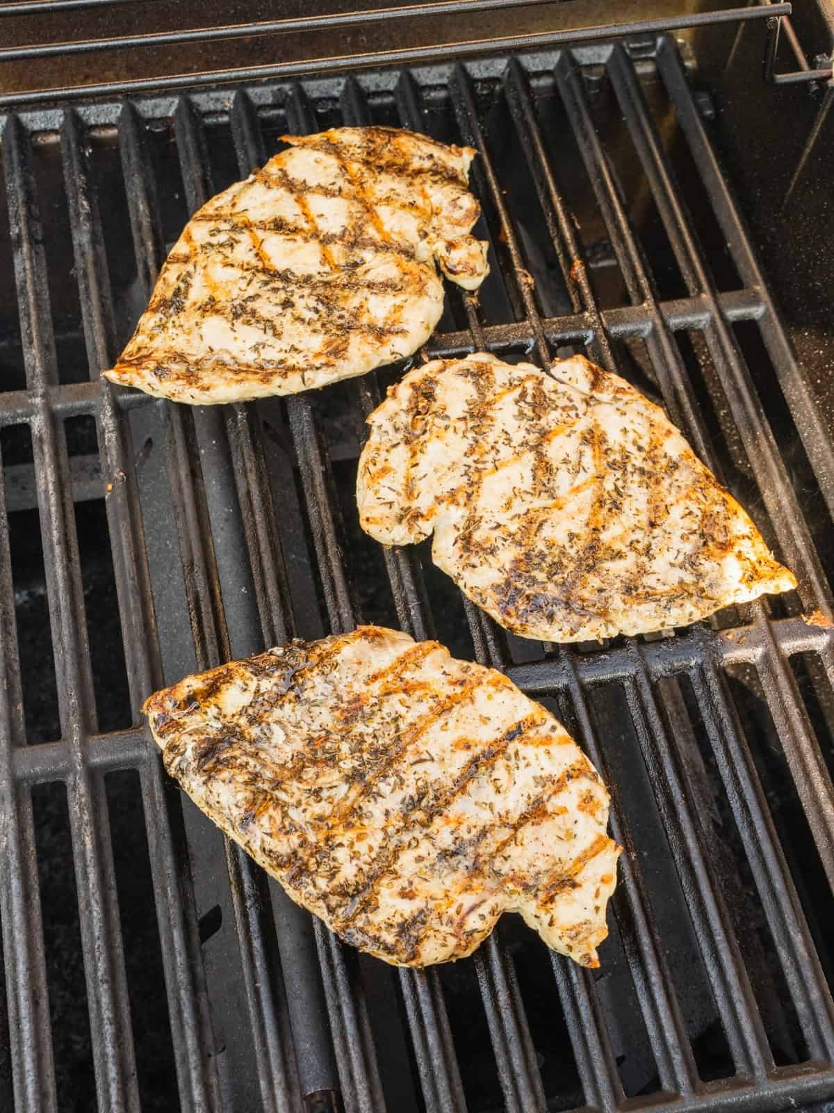 Grilling chicken breasts on a gas grill.