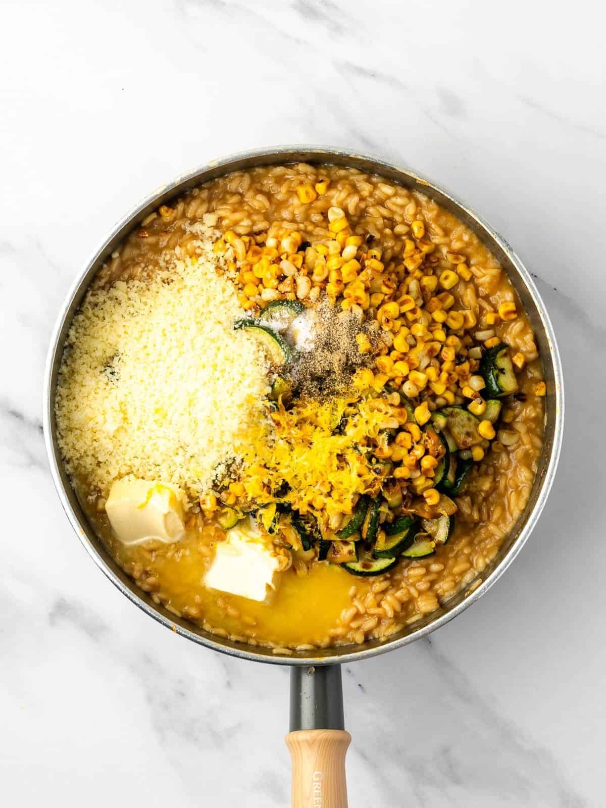 Recipe step showing the vegetables, butter and parmesan being added to cooked rice.