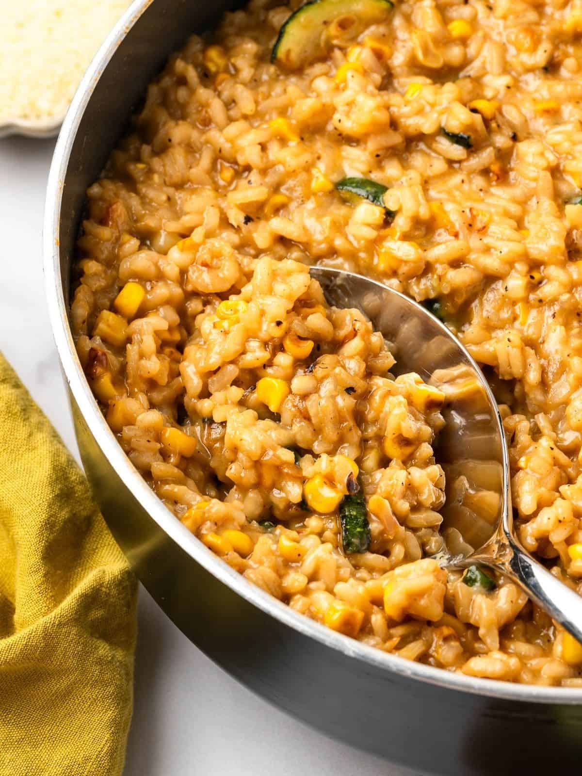 Summer risotto with squash and corn in a sauce pan.