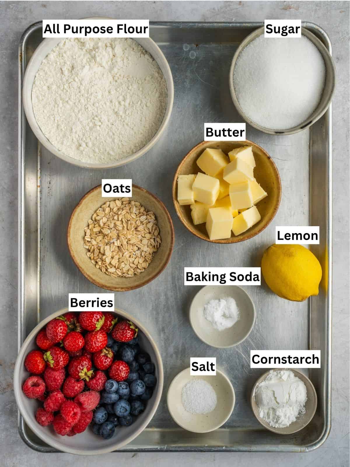 Triple berry bars with oatmeal shortcrust recipe ingredients with individual labels on a metal tray.