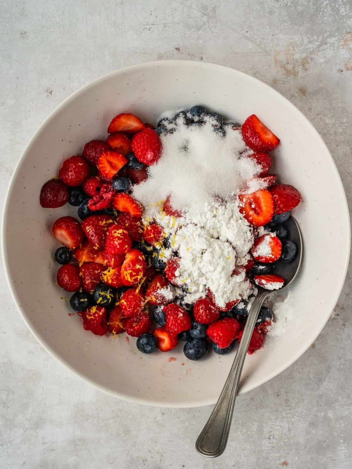 Bowl with berries, sugar, corn starch and lemon zest.