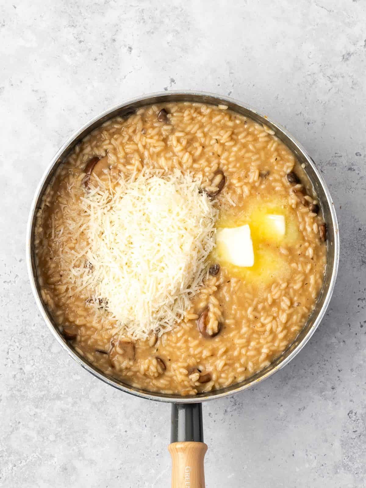 Adding the butter and parmesan to the cooked risotto rice.