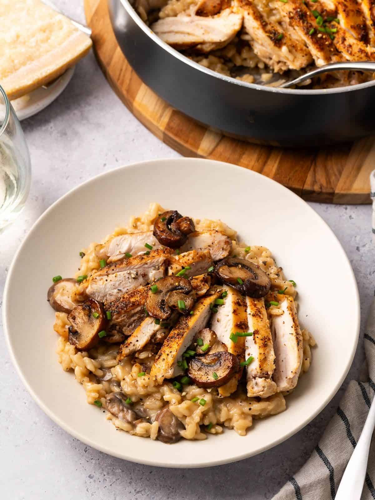 Chicken and mushroom risotto in a bowl garnished with fresh chives.