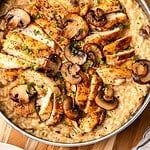 Chicken and mushroom risotto in a sauté pan garnished with fresh chives.