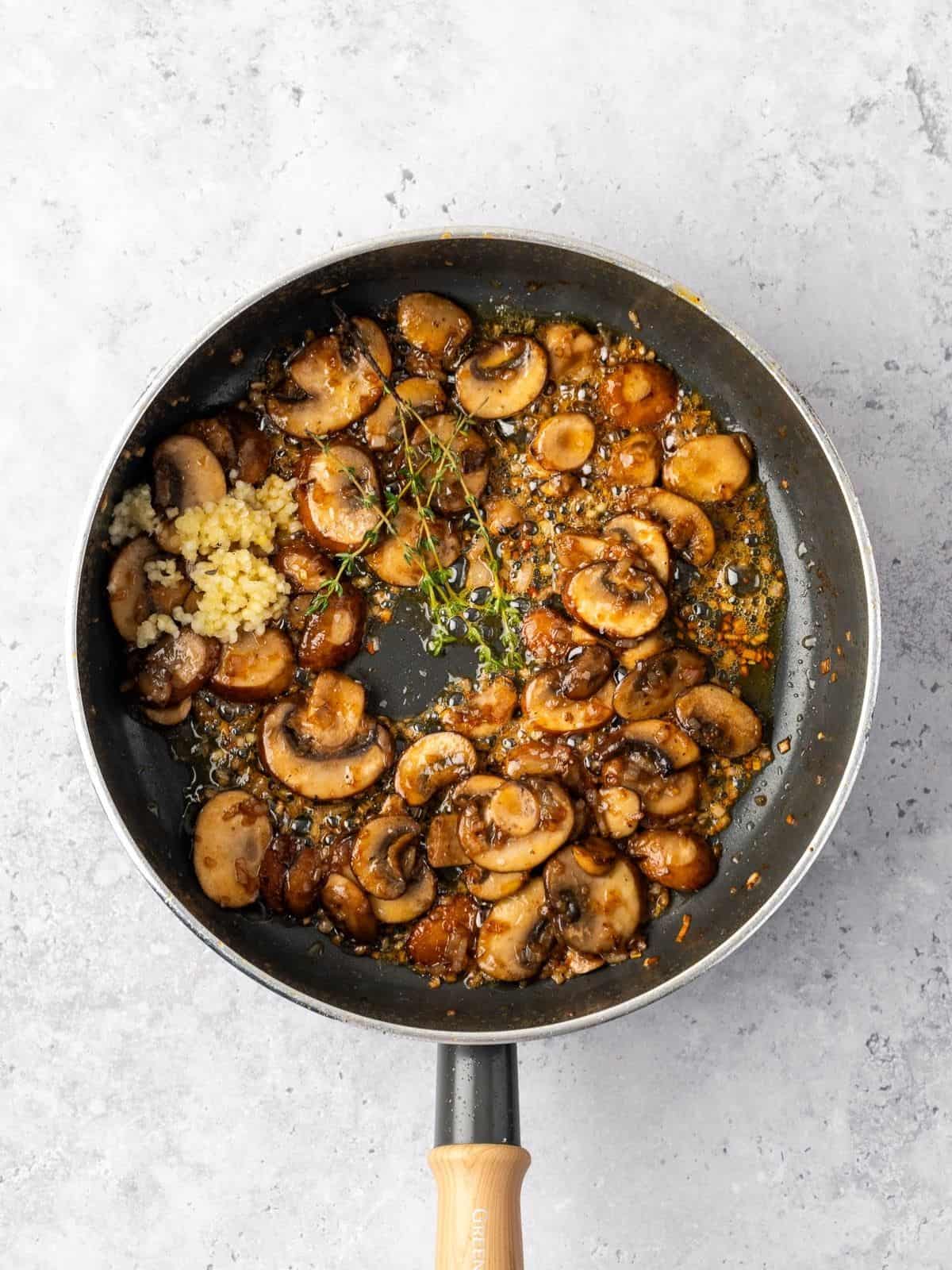 Sauté pan with mushrooms, aromatics and thyme.