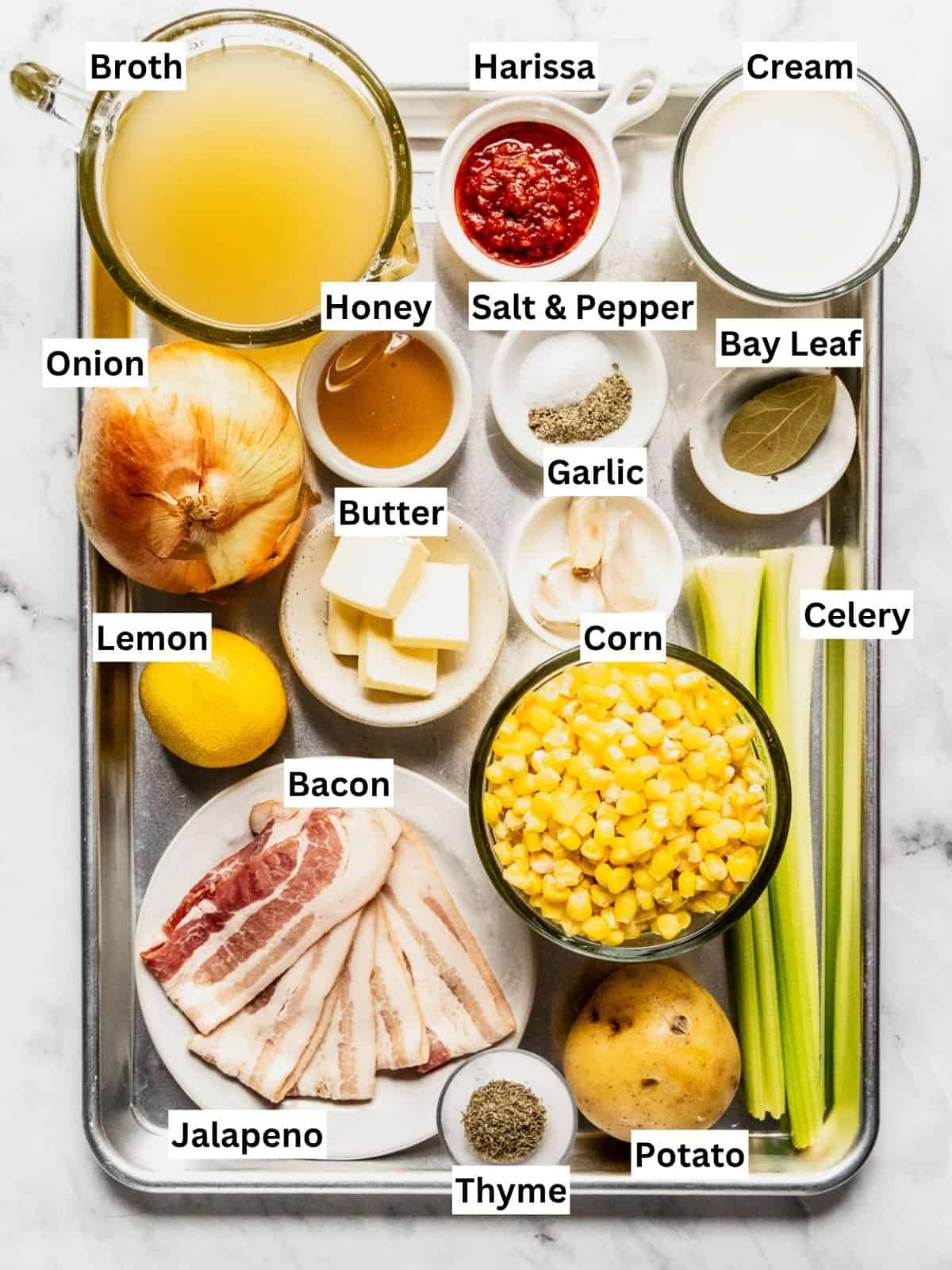 Corn chowder with harissa butter recipe ingredients with individual labels on a metal tray.